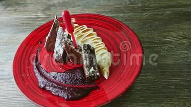 精致的装饰切片巧克力饼与烘焙奶油旋转在红色盘子